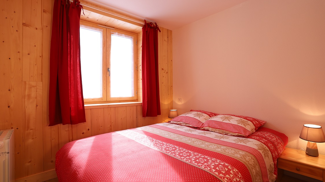 Chambre cosy aux tons rouges et bois clair